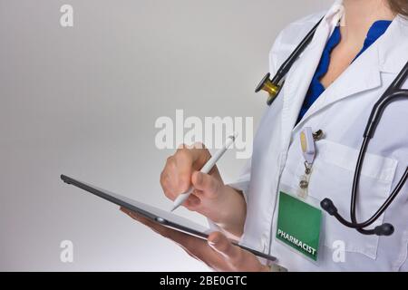 Mitarbeiter im Gesundheitswesen, die ein Tablet zur Durchführung der Gesundheitsversorgung verwenden. Arzt oder Pflegepersonal, das ein Rezept schreibt. Arzthelfer mit Stethoskop Stockfoto