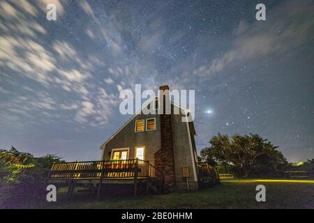 Nachthimmel mit Wolken und Sternen über einem Nantucket-Haus. Stockfoto