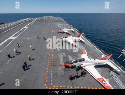 Matrosen, die der Luftabteilung der USS Gerald R. Ford (CVN 78) zugewiesen wurden, tanken T-45C Goshawks auf, die an Training Air Wing 1 und 2 angeschlossen sind, auf Fords Flugdeck am 7. April 2020. Ford ist im Atlantik unterwegs und führt die Qualifikationen von Spediteur durch. (USA Navy Foto von Mass Communication Specialist 2. Klasse Ryan Seelbach) Stockfoto