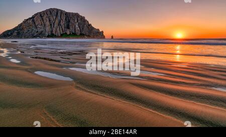 Sonnenuntergang über dem Sandstrand von Morro Rock Stockfoto