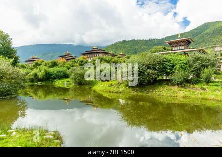 Blick auf Thimphu Dzong vom Ludrong Park mit einem See und Blumen Stockfoto