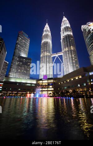 Am frühen Abend Foto der Petronas Towers in Kuala Lumpur, Malaysia mit Reflexion in einem kleinen Springbrunnen Pool. Stockfoto