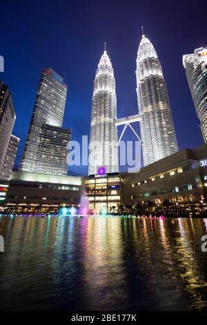 Am frühen Abend Foto der Petronas Towers in Kuala Lumpur, Malaysia mit Reflexion in einem kleinen Springbrunnen Pool. Stockfoto