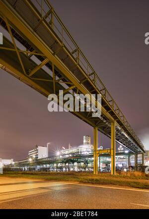 Nachtaufnahme mit beleuchteten petrochemische Produktionsanlage und Pipeline Überführung, Antwerpen, Belgien. Stockfoto