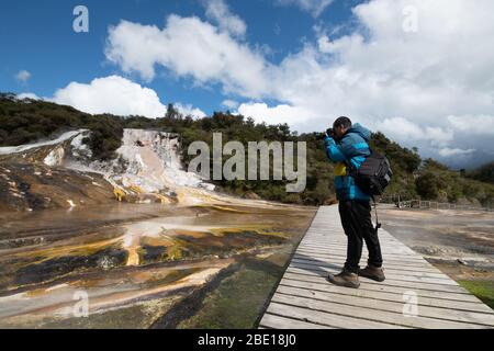 Junge Fotografin, die in Orakei Korako Geothermal, Neuseeland fotografiert. Stockfoto