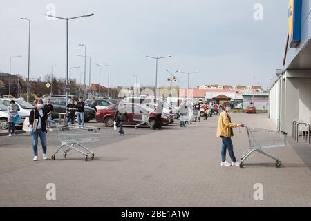 LUBIN, POLEN - 9. APRIL 2020. Kunden in der Schlange vor dem Lidl Supermarkt. Aufgrund des Coronavirus Covid-19 war die Anzahl der Personen in der Th begrenzt Stockfoto