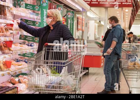 LUBIN, POLEN - 9. APRIL 2020. Kundin mit Gesichtsmaske beim Einkauf im Auchan Supermarkt. Stockfoto