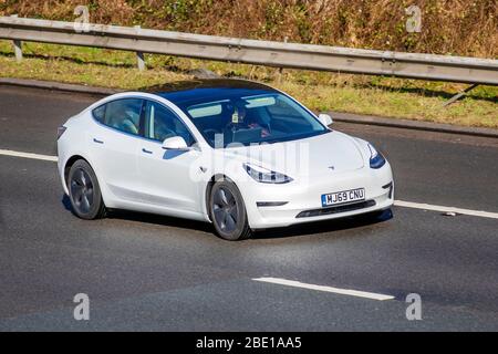 2019 White Tesla Model 3 Long Range AWD EVs, Premium-Elektro-Limousine, elektrische Limousine; Fahrzeug Verkehr bewegende Fahrzeuge, Fahren Fahrzeug auf UK Straßen, Motoren, Autofahren auf der Autobahn M6 Stockfoto