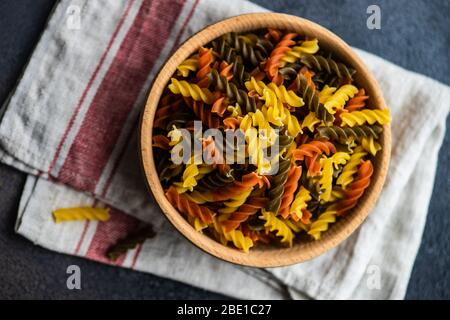 Italienisches Food-Konzept mit Holzschale voller Fusilli bucati Pasta auf Beton Hintergrund mit Kopierraum Stockfoto