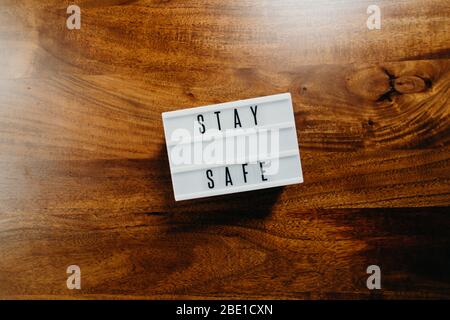 „Safe“-Text in Leuchtkasten auf Holzhintergrund. Stockfoto