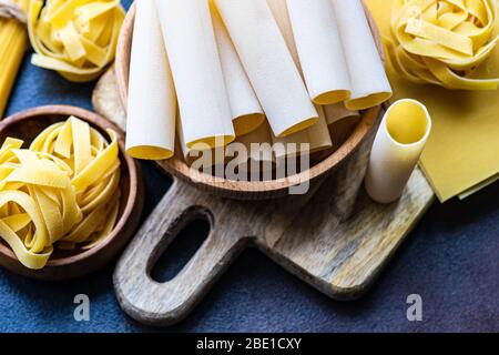 Italienische Pasta-Vielfalt auf dunklem Beton Hintergrund mit Kopierraum Stockfoto