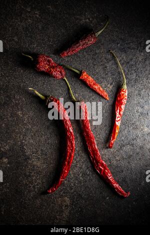 Getrocknete rote Chilischoten auf schwarzem Tisch. Draufsicht. Stockfoto