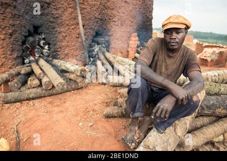 Kampala / Uganda - 20. September 2016: Schwarze Männer arbeiten in der Lehmziegelfabrik in der Hauptstadt Ugandas in der Nähe eines Backsteinofens Stockfoto