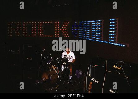 1981 - ein Musiker sitzt am Schlagzeug in der Dunkelheit einer Konzerthalle vor Beginn des Rock'n'Roll Konzert Stockfoto