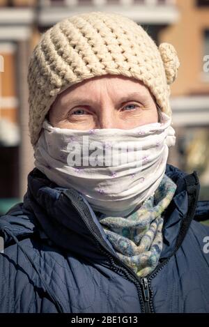 Eine arme ältere Frau trägt eine selbstgemachte Maske, um sich vor Viren wie dem Coronavirus, auch Covid-19 genannt, oder SARS und MERS zu schützen. Sie ist in einem Stockfoto