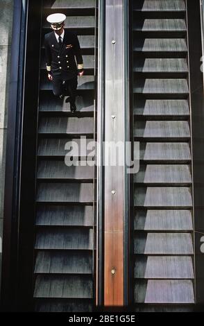 1982 - eine Marine Kapitän wechselt in U-Bahn-Netz und der Stadt auf einer Rolltreppe. Stockfoto