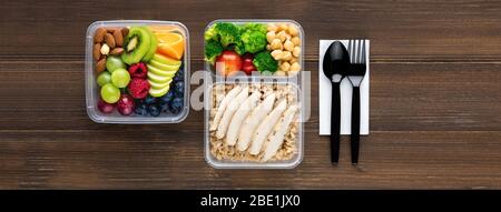 Draufsicht der gesunden nährstoffreichen Lebensmittel in Take Away Boxen mit Löffel und Gabel auf Holz Tisch Banner Hintergrund gesetzt Stockfoto