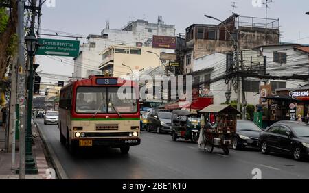 Bangkok, Thailand - 27. Februar 2020: Typische Bangkok Fahrzeuge: Ein alter Bus, ein 'Tuktuk' und ein Händlerwagen. Stockfoto