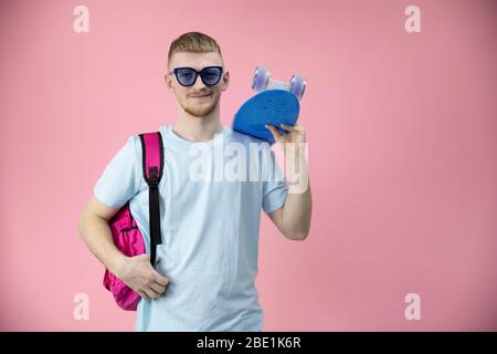 Portrait des kaukasischen Jungen Student hält Skateboard Pennyboard auf der Schulter Stockfoto