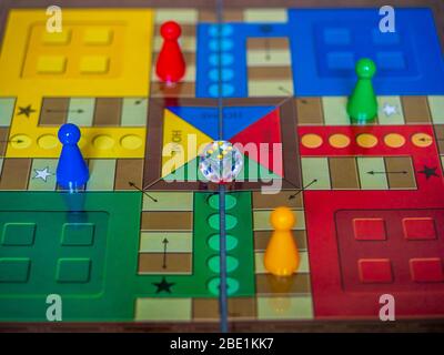 Stücke und einen Würfel auf einer Ludo Brettspiel Stockfoto