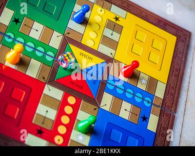 Stücke und einen Würfel auf einer Ludo Brettspiel Stockfoto