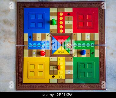 Stücke und einen Würfel auf einer Ludo Brettspiel Stockfoto