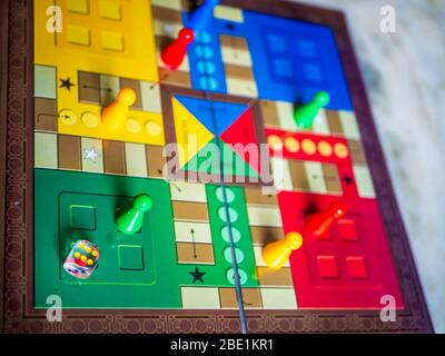 Stücke und einen Würfel auf einer Ludo Brettspiel Stockfoto