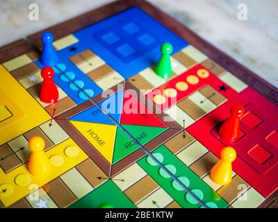 Stücke und einen Würfel auf einer Ludo Brettspiel Stockfoto