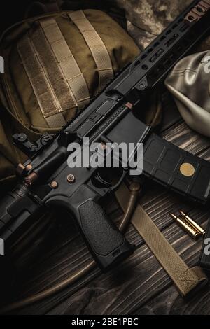 Moderne automatische Karabiner, Rucksack und Gasmaske auf einem Holztisch. Ein Set von Kämpfernden bereit für jede Kampfbedingung. Stockfoto