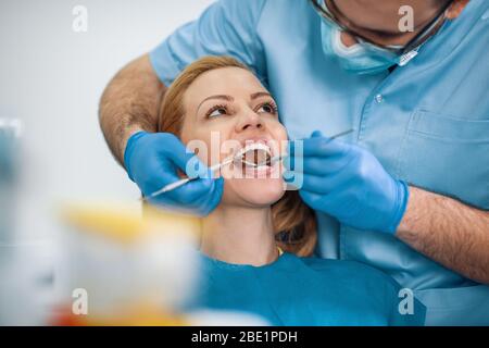 Porträt der weiblichen Patientin, die bei Dentist behandelt wird.Dentist Untersuchung der Zähne eines Patienten in der Zahnarztpraxis. Stockfoto