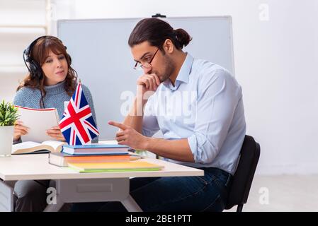 Junger Schüler und männlicher englischlehrer im Klassenzimmer Stockfoto