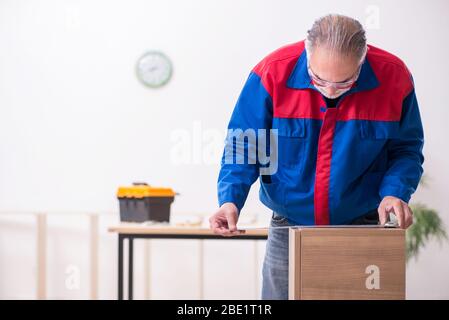 Alte Tischler, die in Innenräumen an Möbeln arbeiten Stockfoto