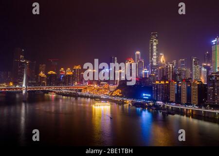 Chongqing, China - 22. Dez 2019: Luftaufnahme der Hong Ya dong Höhle, historische Volksreligionstadt mit beleuchteten Wolkenkratzern mit Chongqing auf Chinesisch Stockfoto