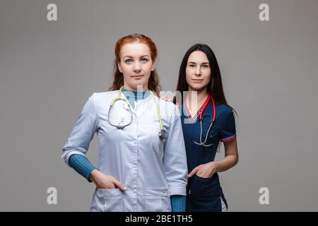 Zwei professionelle Ärzte mit Stethoskopen. Gemeinsam gegen COVID-19 oder Coronavirus kämpfen. Stockfoto