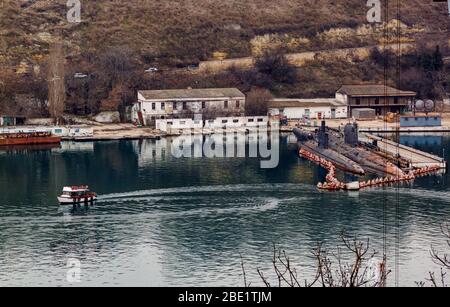 Sewastopol, Russland - Februar 19 2020: Vergnügungsboot und zwei U-Boote in South Bay. Stockfoto