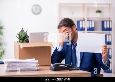 Junger Mann, der von seinem Arbeitsplatz aus gefeuert wird Stockfoto