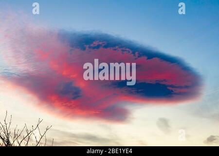 Die spektauläre Linsenwolkenbildung gegen einen roten Himmel sieht aus wie UFO, Helensburgh, Schottland, Großbritannien Stockfoto