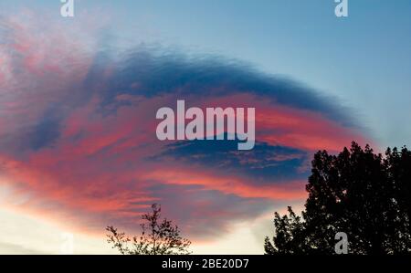 Die spektauläre Linsenwolkenbildung gegen einen roten Himmel sieht aus wie UFO, Helensburgh, Schottland, Großbritannien Stockfoto