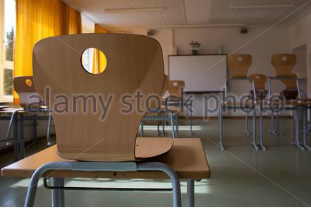 Ein Schulstuhl, der auf einem Schreibtisch in einem deutschen Klassenzimmer steht, bleibt wegen des Corona-Virus geschlossen. Stockfoto