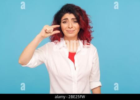 Klein. Porträt von missfiel Hipster Frau mit Phantasie roten Haaren machen ein wenig Geste und suchen mit unzufriedenen Gesicht, zeigt Minimum. Stockfoto