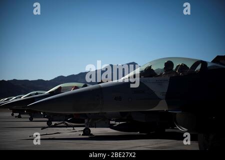 F-16C Kampffalken, die der 64. Aggressor Squadron-Aufstellung auf der Fluglinie zugewiesen wurden, um den Start am 3. April 2020 auf der Nellis Air Force Base, Nevada, vorzubereiten. Die 64. Aggressor Squadron flog eine geplante Trainingsmission mit allen blauen Flugzeugen, was die Wertschätzung und Unterstützung der Basis für medizinische Fachkräfte im Las Vegas Valley symbolisiert, darunter diejenigen im Mike O’Callaghan Military Medical Center und Ersthelfer, die gegen die COVID-19-Pandemie kämpfen. (USA Air Force Foto von Senior Airman Jeremy Wentworth) Stockfoto