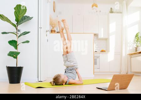 Junge im Schulterstand Pose auf Yoga-Matte zu Hause Stockfoto