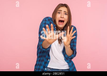 Ich fürchte mich! Porträt von schockierten Mädchen in karierten Hemd schreien in Schrecken und Angst, halten die Hände angehoben, um sich zu verteidigen, Panikattacke. ind Stockfoto