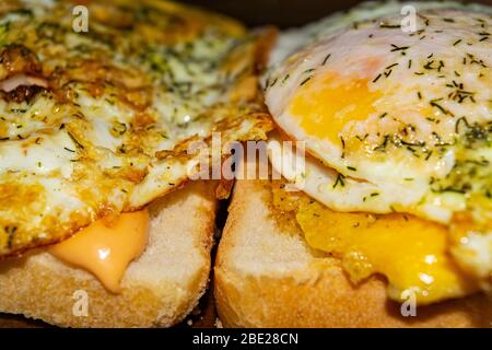 Sandwiches mit Spiegeleiern mit Dill und Soße auf Weizenbrot. Nahaufnahme Stockfoto