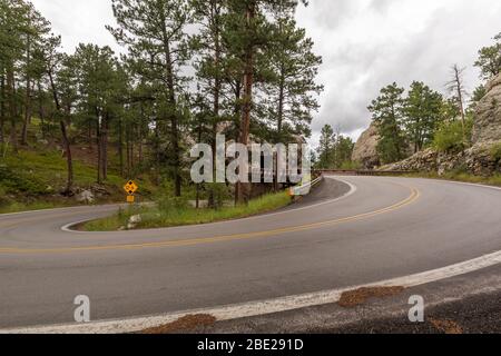 Eine Straße mit einer über- und Unterbrücke mit einem Tunnel durch einen Felsen. Stockfoto