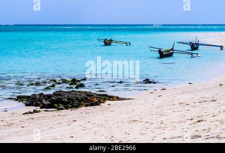 Atemberaubender weißer Sandstrand der Insel Nosy Ve mit typischen Auslegerpirogues im Hintergrund, Indischer Ozean, Madagaskar Stockfoto