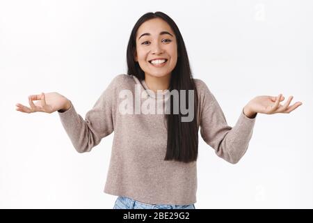 Unvorsichtige und unbelästigte lachende glückliche asiatische Frau mit dunklen Haaren, zucken und Hände seitlich ausbreiten uninvolved, uninteressiert an Thema, nicht wissen Stockfoto