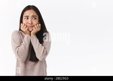 Asiatische Mädchen etwas besorgt über zukünftige Prüfungen, hält Hände jawline dumm und ängstlich, Blick weg runwning alarmiert, überreagieren nicht wissen, was tun Stockfoto