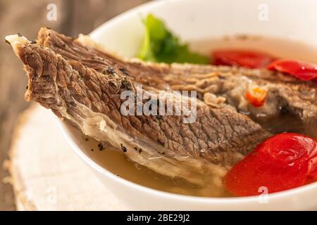 Shorpo in einem weißen Teller mit einem Stück Rindfleisch in einer Brühe mit Gemüse aus nächster Nähe Stockfoto