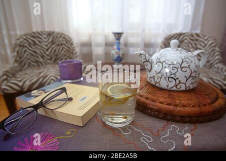 Verbringen angenehme Zeit mit Kräutertee und Bücher während dieser Tage bleiben wir zu Hause Stockfoto